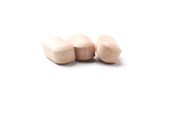 Lion’s mane mushrooms tablets that have beneficial effects on the body, especially the brain, heart, and intestines. Bright paper background. Soft focus. Close up. Copy space.	
