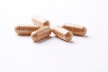 Ashwagandha (Withania somnifera) capsules. Concept for a healthy dietary supplementation. Bright paper background. Close up. Copy space.	