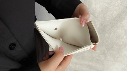 Close-up person opening empty wallet showing broke financial in debt from over expenses. The...