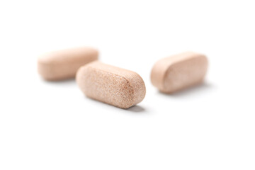 Lion’s mane mushrooms tablets that have beneficial effects on the body, especially the brain, heart, and intestines. Bright paper background. Soft focus. Close up. Copy space.	