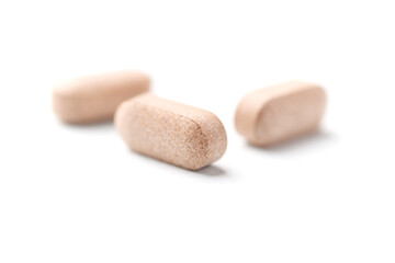 Lion’s mane mushrooms tablets that have beneficial effects on the body, especially the brain, heart, and intestines. Bright paper background. Soft focus. Close up. Copy space.	