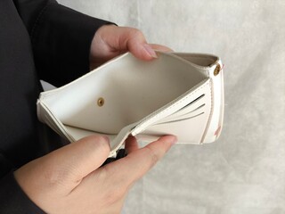 Close-up person opening empty wallet showing broke financial in debt from over expenses. The...