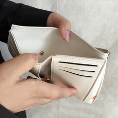 An open empty wallet in a woman's hands. The concept of poverty, lack of money, and debt.