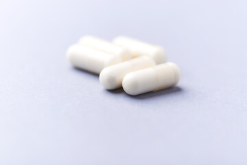 Creatine capsules on paper background. Soft focus. Close up. Copy space.	