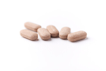 Ashwagandha (Withania somnifera) tablets on paper background. Soft focus. Close up. Copy space.	