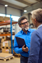 Two Colleagues Discussing Work Details in a Warehouse Environment