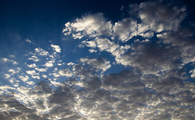 Fluffy scattered clouds in bright blue sky