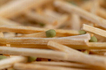 matches scattered in a large pile, a large number of thin wooden matches with a head, side view