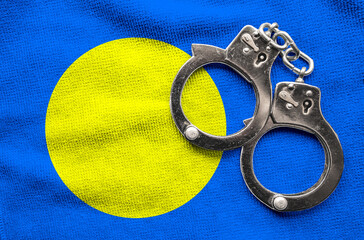 Flag of Palau and police handcuffs. Crime and offenses in country Concept

