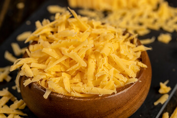 grated hard yellow cheese for cooking, grated cheese for cooking and folded into a wooden bowl