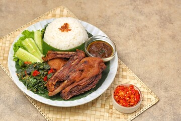 Bebek goreng bumbu hitam. Madura's signature black spiced duck is savory and spicy