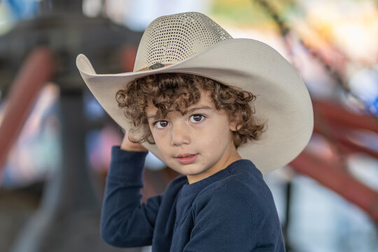 Close-up of young boy in cowboy hat looking at camera