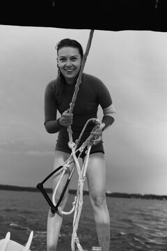 Black and white portrait of smiling woman holding a wakeboarding rope