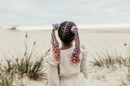 Girl on a beach with colourful braids