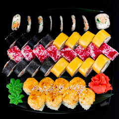 Large assorted sushi set with various rolls, nigiri, and sashimi on wooden board