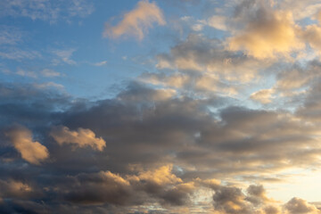 Soft evening light on scattered clouds in a blue sky
