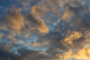 Soft evening light on scattered clouds in a blue sky
