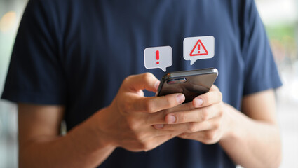 Person holding a smartphone with notification alerts and warning signs on the screen