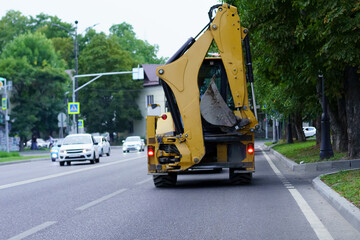 Construction vehicle working on street repairs near residential area in early morning