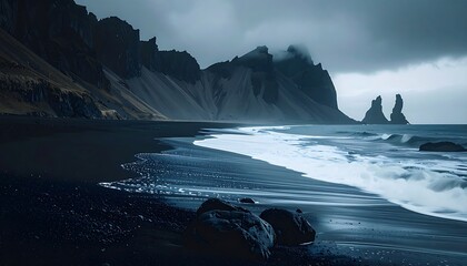Dark, moody coastal scene; black sand beach, waves washing ashore, dramatic cliffs shrouded in mist under a brooding sky