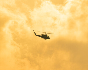 Camouflage colour bell 212 helicopter in hover over a large water tank and ready for departure	