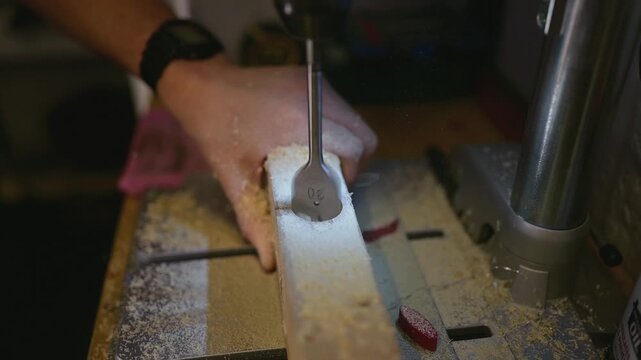 Top view close-up of a wooden plank being drilled on a machine in a carpentry workshop. Precision woodworking process from above. High quality 4k footage