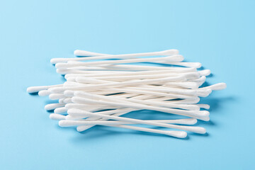 White cotton swabs on blue background. 
