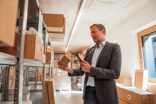 Business manager checking parcels in warehouse logistics setting
