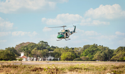 Camouflage colour bell 212 helicopter in hover over a large water tank and ready for departure	
