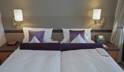 Luxurious suite stateroom cabin room onboard luxury yacht cruise ship cruiseship liner with bedroom and living area in purple and creme with wood in modern Art Deco interior design