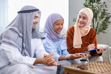 Middle east muslim parent is teaching their kid to start family saving and investment for financial and monetary banking education concept