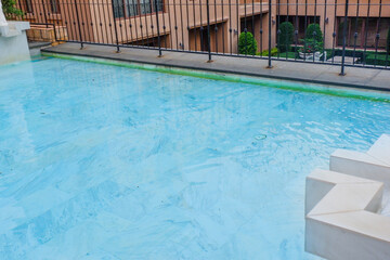 Empty swimming pool with sunbed and white umbrella in resort hotel for vacation leisure and white...