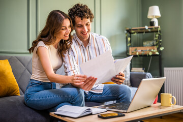 Couple discussing mortgage loan while checking home finances. They are checking financial documents...