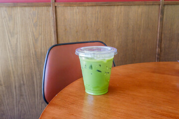 Iced matcha latte in glass on wooden table, authentic Japanese matcha latte made from Uji tea,Matcha green tea,Organic Green Matcha Tea.