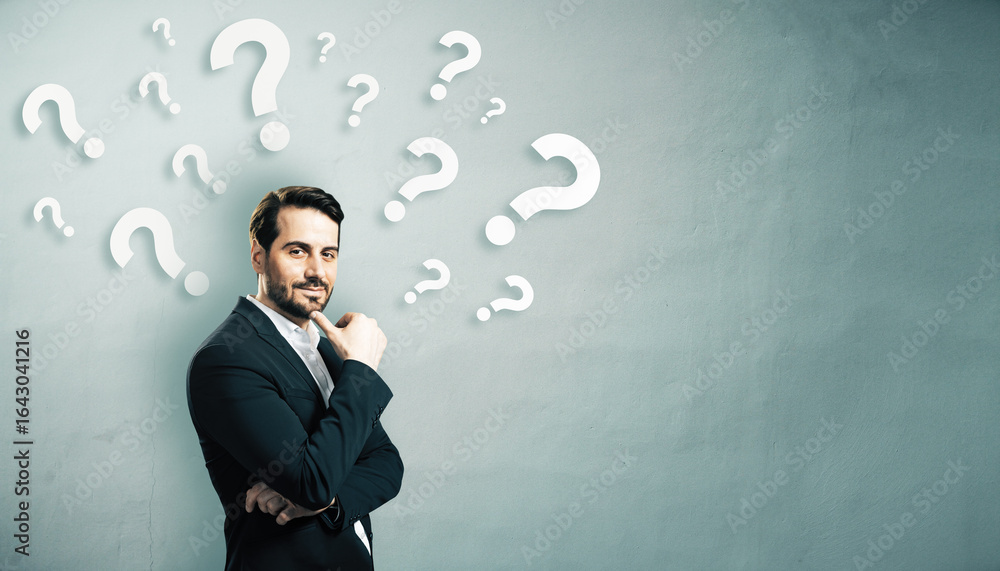 Poster thoughtful businessman standing in front of a wall filled with floating question marks, symbolizing 