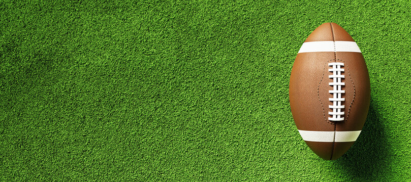 American football ball on green field turf background with copy space for branding or advertising sports template design concept mockup. 3D Rendering