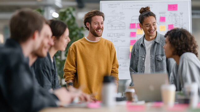 Creative professionals collaborate in a modern office. Diverse team brainstorming ideas with whiteboard, notes  laptop. Positive, innovative work culture concept.
