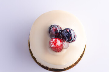 White cake topped with berries and cream