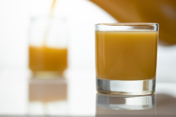 A glass of orange juice with a straw