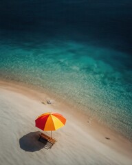 Una vista aérea de una playa serena con una sombrilla roja y amarilla y una tumbona.