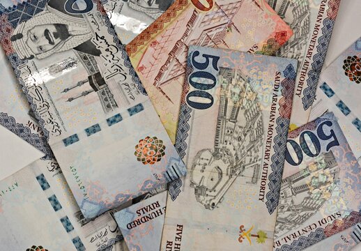 Top view of Saudi Arabian Riyal banknotes, 500 and 100 denominations, concept of finance and economy in Saudi Arabia.