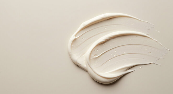 White cosmetic cream texture smear on a light beige background. Luxurious skincare product swatch for beauty and cosmetology concepts.