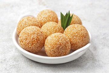 Onde-onde or Kuih Bom or Banh Cam or Jian Dui is a traditional snack made from sticky rice flour with a skin coated with sesame seeds and filled with mungbean