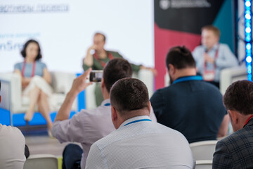 Audience attentively participating in a business seminar. Professionals engaged during the informative session.