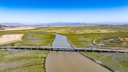 aerial view of landscape around Sonoma creek bridge located north of San Francisco Bay Area in Northern California with mountain landscape in background
