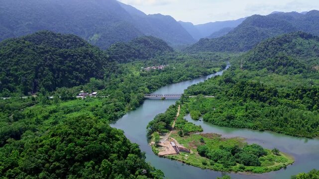Scenic Aerial View of a Tropical River and Mountain Road Bridge