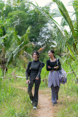 Indonesian women walking together in nature after outdoor exercise with yoga gear