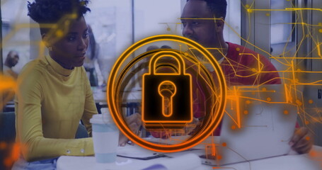 Collaborating tech professionals typing on laptop at office table, with padlock graphic overlay
