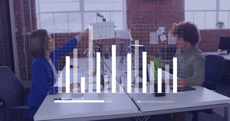 Handing printed documents office coworkers at loft-style desk, with monitors and bar-chart overlay