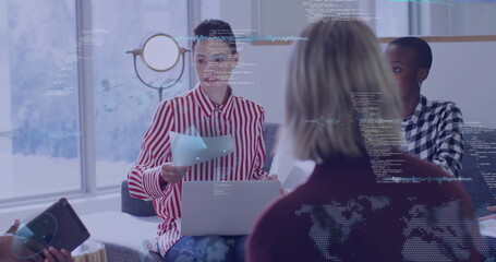 Reviewing printed documents woman in red white striped blouse leading meeting in lounge with laptop